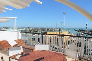 balcón con sillas, mesa y puerto deportivo en Residence Fiorella, en Cattolica