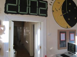 zegar wiszący na ścianie obok korytarza w obiekcie Carpe Noctem Hostel w Budapeszcie