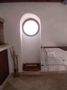 a white room with a round window and a chair at Old castle S. Croce in Cagliari