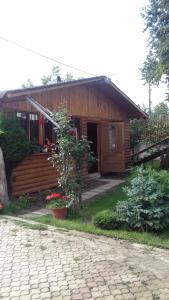 a log cabin with a porch and a brick driveway at Casa Nobilis in Gura Humorului