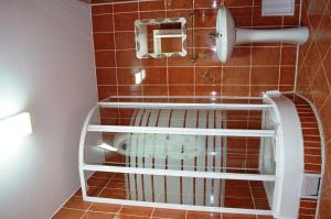 a bathroom with a bird cage on the wall at Hotel Darina in Târgu-Mureş