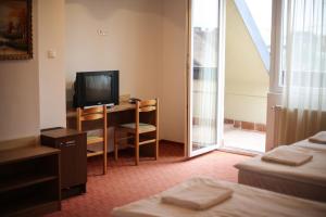 a hotel room with a tv and a desk with a computer at Silver Hotel Budapest City Center in Budapest
