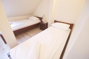 two beds in a small room with white walls at Willa3D in Mrzeżyno