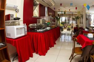a restaurant with a counter with red tables in a room at Ara Mar Praia Hotel in Fortaleza