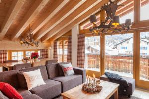 ein Wohnzimmer mit einem Sofa und einem Tisch in der Unterkunft Vrony Apartments by Hotel Walliserhof Zermatt in Zermatt