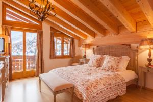 a bedroom with a bed in a room with wooden ceilings at Vrony Apartments by Hotel Walliserhof Zermatt in Zermatt