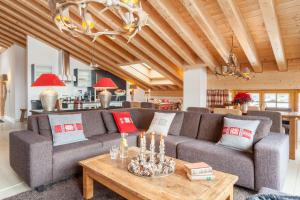 a living room with a couch and a table at Vrony Apartments by Hotel Walliserhof Zermatt in Zermatt