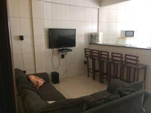 uma sala de estar com um sofá e uma televisão em Casa Relaxar em Salvador