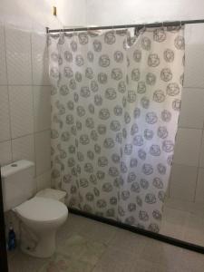 uma casa de banho com um WC e uma cortina de chuveiro em Casa Relaxar em Salvador