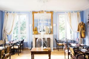 comedor con paredes y mesas azules y chimenea en Maison d'hôtes Stella Cadente, en Provins