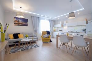 a living room and kitchen with a couch and a table at Rajska Apartament- Gdańsk in Gdańsk