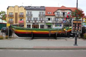 a large boat sitting in front of some buildings at Willa3D in Mrzeżyno