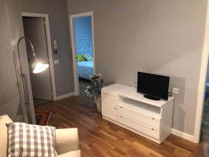 una sala de estar con TV en un armario blanco en Apartamento Lula, en Santiago de Compostela
