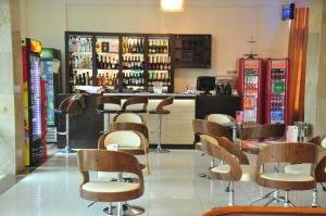 um restaurante com cadeiras e um bar com garrafas de vinho em Citiheight Hotel em Ikeja