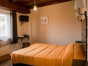 an orange bed in a room with a window at Sleep'n go Hotel in Fiumicino