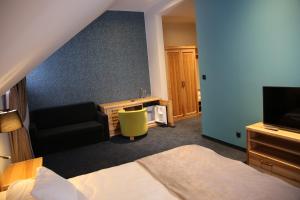 a hotel room with a bed and a television at Dwór Kukuczka in Istebna