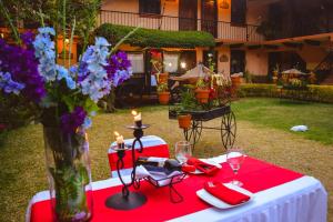 a red and white table with candles and flowers on it at Nuestras Raíces Hotel - Museo - Restaurante in San Cristóbal de Las Casas
