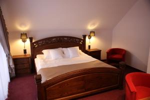 a bedroom with a bed and a red chair at Dwór Kukuczka in Istebna