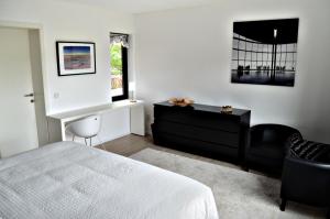 una camera con letto, scrivania e sedia di Nena Guesthouse a Lovanio
