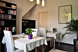 a dining room with two tables and white chairs at Nena Guesthouse in Leuven