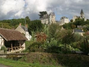 a city with a large castle in the background at La maison des caves in Châteauvieux