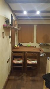 a kitchen with a wooden table and two chairs at Eco Relax in Passo del Tonale