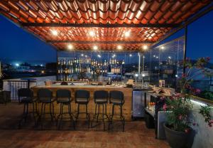 a bar on the roof of a building with bar stools at Comala Bed & Breakfast in Oaxaca City