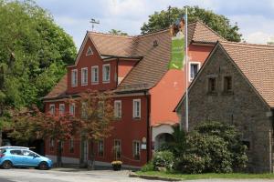 ein blaues Auto, das vor einem Gebäude parkt in der Unterkunft Landidyll Hotel Erbgericht Tautewalde in Wilthen