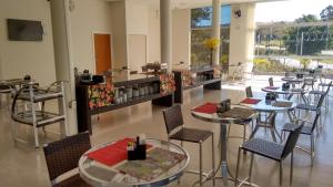 ein Restaurant mit Tischen und Stühlen in einem Raum in der Unterkunft Hotel 494 Oliveira-MG in Oliveira