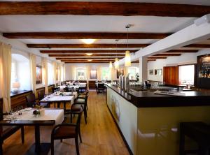 un restaurante con mesas y sillas y un bar en Landidyll Hotel Erbgericht Tautewalde, en Wilthen