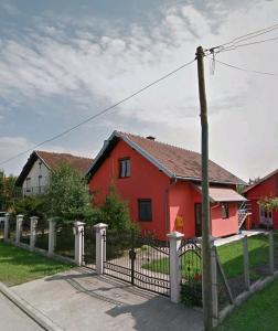 una casa roja con una valla delante en Prle Apartment, en Novi Sad