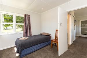 מיטה או מיטות בחדר ב-Waitangi Beach Bach 30A