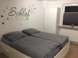 ein Schlafzimmer mit einem Bett mit einem Schild an der Wand in der Unterkunft Ferienhaus Kluntje in Emden