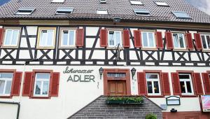 un edificio con persianas rojas y un cartel en él en Landhotel Schwarzer Adler, en Tiefenbronn