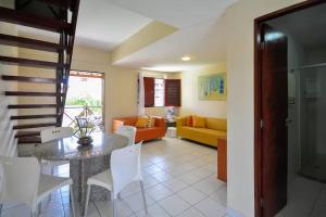 a dining room and living room with a table and chairs at Merepe Residencial in Porto De Galinhas