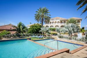 a large swimming pool in front of a house at Curacao Luxury Holiday Rentals in Willemstad