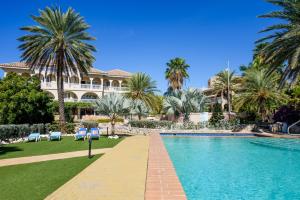a resort with a swimming pool and palm trees at Curacao Luxury Holiday Rentals in Willemstad +15 photos