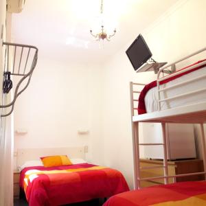a bedroom with a bed and a desk at Hostal Casa Chueca in Madrid