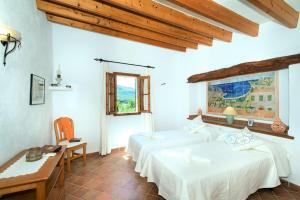ポリェンサにあるOwl Booking Villa El Campet - Rustic Stayのベッドルーム1室(ベッド2台、デスク、窓付)