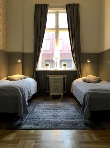 a bedroom with two beds and a window at Hotell Kungsängstorg in Uppsala