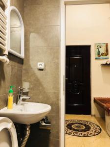 uma casa de banho com um lavatório e uma porta preta em Heart of Old Tbilisi Apartments 2 em Tbilisi