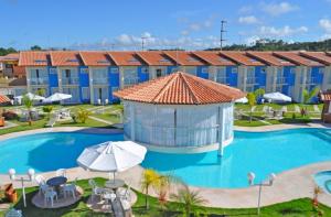 un complexe avec une grande piscine et un bâtiment dans l'établissement Ap (Flat) Taperapuã Porto Seguro, à Porto Seguro