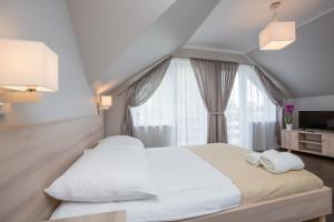 um quarto com uma grande cama branca e uma janela em Willa Przystań em Jastarnia