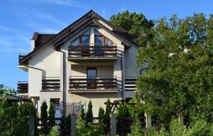 a large white house with a fence in front of it at Willa Przystań in Jastarnia