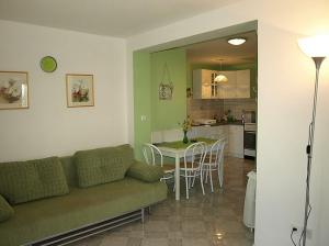 ein Wohnzimmer und eine Küche mit einem Sofa und einem Tisch in der Unterkunft Apartmani Pergola in Kukljica