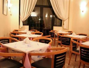 un ristorante con tavoli e sedie con tovaglie bianche di Aktaion City Hotel a Gythio