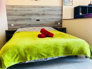 a green bed with two red pillows on it at Atlantic Ocean View in Adeje