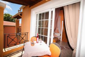 a table with a bottle of wine on a balcony at Apartments Mary in Agios Gordios