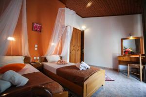 a bedroom with two beds and a sink and a mirror at Apartments Mary in Agios Gordios