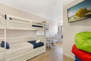 a bedroom with bunk beds and a dining room at Beach House Motel in Townsville